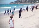 Wakacje z emigrantami: oszołomieni turyści obserwują inwazję na hiszpańskiej plaży.